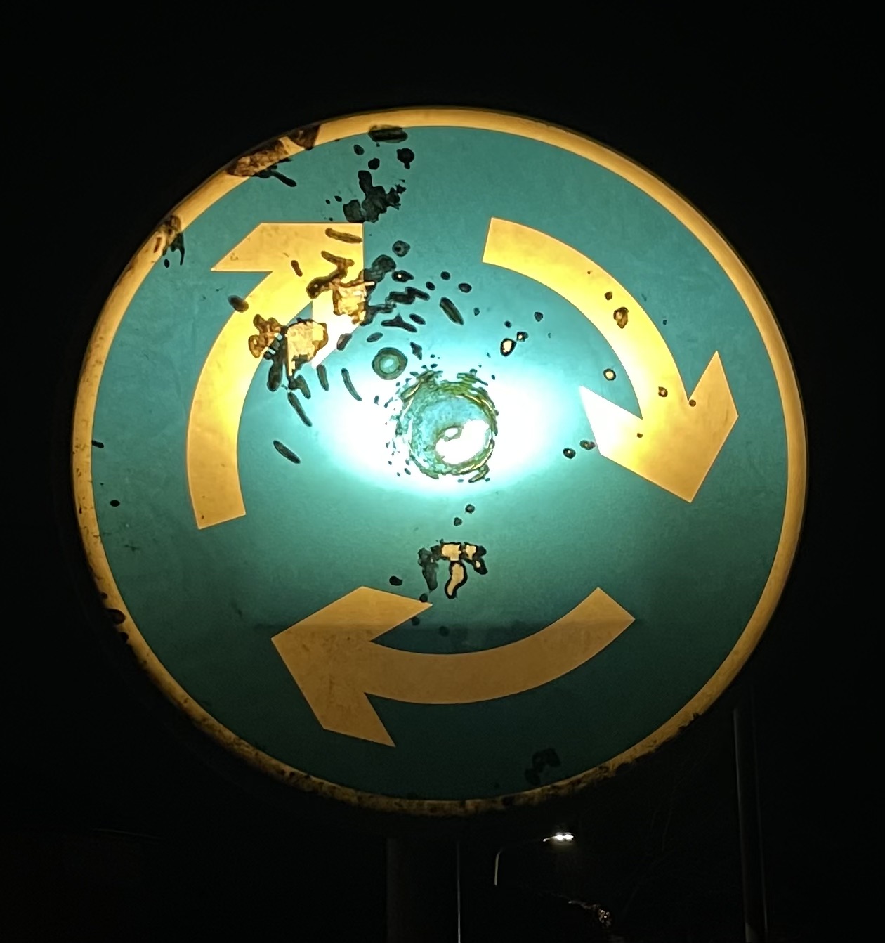 Green street roundabout with three yellow arrows in clockwork direction